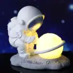 Objet scientifique, figurine d'astronaute avec planète lumineuse, décoration de science et d'espace.
