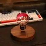 Ampoule LED avec cœur lumineux sur socle en bois.