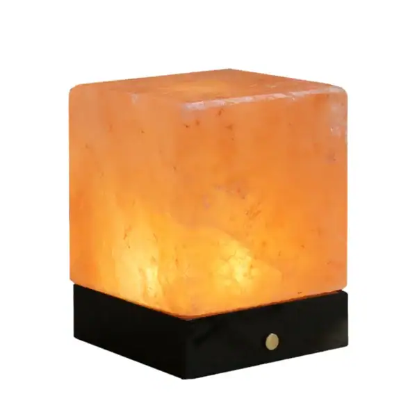 Lampe de sel Himalaya illuminée sur socle noir, idéale pour la décoration d'intérieur et la création d'une ambiance chaleureuse.
