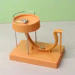 Balancier à billes pour expérience de physique, illustrant la conservation de l'énergie et la dynamique des corps en mouvement.