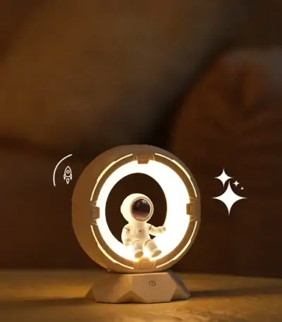 Petite décoration de vaisseau spatial lumineux avec un astronaute en costume blanc, idéale pour une ambiance scientifique ou futuriste.