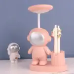 Poupée de décoration en forme d'astronaute avec casque rose et accessoires de science, idéale pour une décoration de bureau ou une chambre d'enfant.