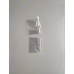 Pendentif en verre transparent avec effet miroir, posé sur une surface lisse, reflétant la main et l'environnement.