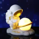 Vêtement d'astronaute en figurine avec planète lumineuse, décoration de style spatial pour la maison ou le bureau.