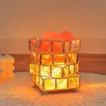 Lampe de table en cubes en verre orange diffusant une lumière chaleureuse.