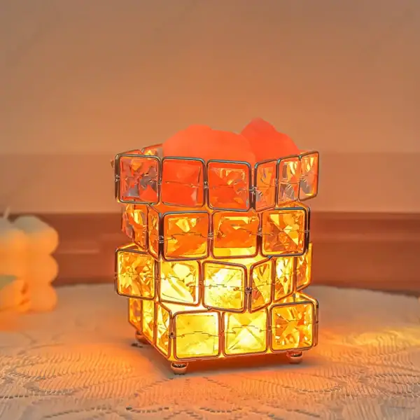 Lampe de table en cubes en verre orange diffusant une lumière chaleureuse.