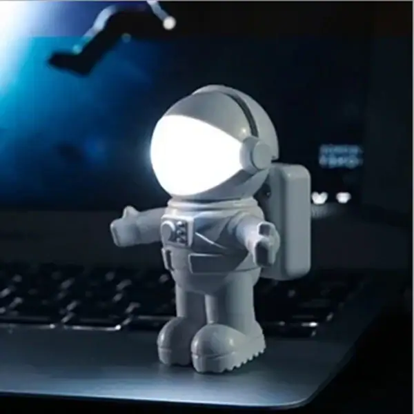 Petite figurine d'astronaute en plastique avec lumière LED intégrée, idéale pour la décoration de bureau ou chambre à thème scientifique, apportant une touche futuriste et ludique.