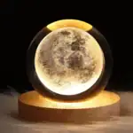 Boule de cristal représentant la lune avec éclairage intérieur, idéale pour décoration scientifique ou thématique lunaire.