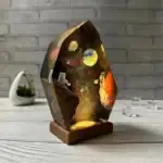 Sculpture en résine représentant un paysage spatial avec planètes, astronautes et étoiles, illuminée pour un effet galactique.