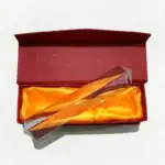 Lame de microscope en verre dans une boîte cadeau rouge avec intérieur en satin orange, idéale pour collection ou décoration scientifique.