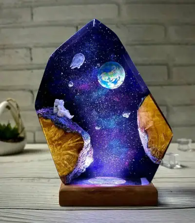 Panneau lumineux en résine avec scène spatiale, planète Terre, astronaute flottant, étoiles et galaxie, sur support en bois, décoration originale pour passionnés d'astronomie.