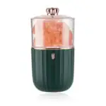 Presse-agrumes électrique en forme de capsule avec corps vert foncé et couvercle rose doré, idéal pour extraire le jus d'agrumes frais à la maison.