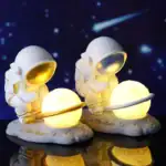 Lampe décorative astronautes avec planètes lumineuses.