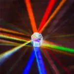 Pendentif en cristal transparent avec rayons lumineux multicolores émanant de ses facettes, créant un effet visuel captivant.