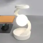 Lampe de bureau design en forme de spirale blanche avec une lumière douce, idéale pour un espace de travail ou une décoration scientifique.