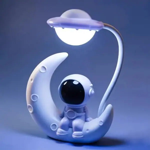 Véhicule spatial décoratif en forme de lune avec un petit astronaute, idéal pour la décoration de chambre ou comme objet de collection sur le thème de l'espace.