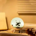 Lampe de bureau en forme de planète avec surface lumineuse et détails noirs, idéale pour une décoration scientifique ou un espace de travail inspirant.