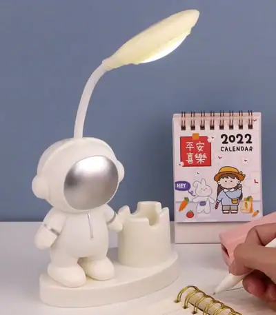 Lampe de bureau originale représentant un astronaute avec une lampe flexible, idéale pour la décoration de bureau ou chambre.