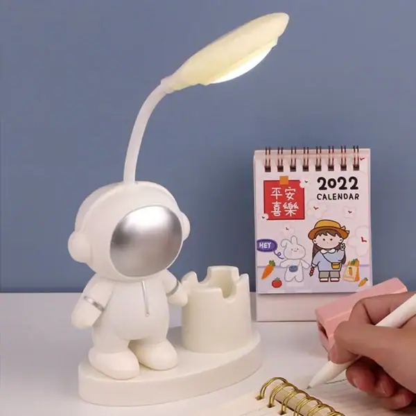 Lampe de bureau originale représentant un astronaute avec une lampe flexible, idéale pour la décoration de bureau ou chambre.