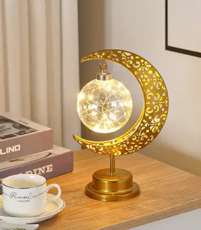 Lampe décorative en forme de lune avec étoile filante, éclairage LED chaud, design élégant en métal doré, parfait pour décoration intérieure ou bureau.