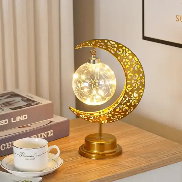 Lampe décorative en forme de lune avec étoile filante, éclairage LED chaud, design élégant en métal doré, parfait pour décoration intérieure ou bureau.