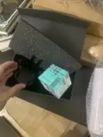 Pendentif en verre scientifique avec support métallique, présenté dans une boîte noire, idéal pour décoration ou collection scientifique.