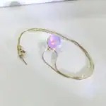 Collier élégant avec pendentif en perle irisée aux reflets multicolores, suspendu à une chaîne fine en métal doré, idéal pour la décoration scientifique et la mode.