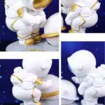 Figurine d'astronaute blanche avec détails dorés, décorant un espace de science et décoration.
