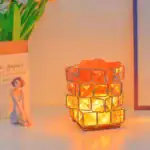 Une lanterne décorative en verre orange, inspirée par un thème scientifique, émet une lumière chaleureuse, idéale pour une ambiance cosy ou un espace de décoration original.