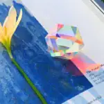 Objet scientifique en verre avec effet holographique, posé sur une surface bleue, illustrant un objet décoratif ou expérimental.