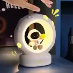 Lumière de veille lunaire avec un astronaute et un petit poussin, idéale pour la décoration de chambre d'enfant ou comme veilleuse éducative.