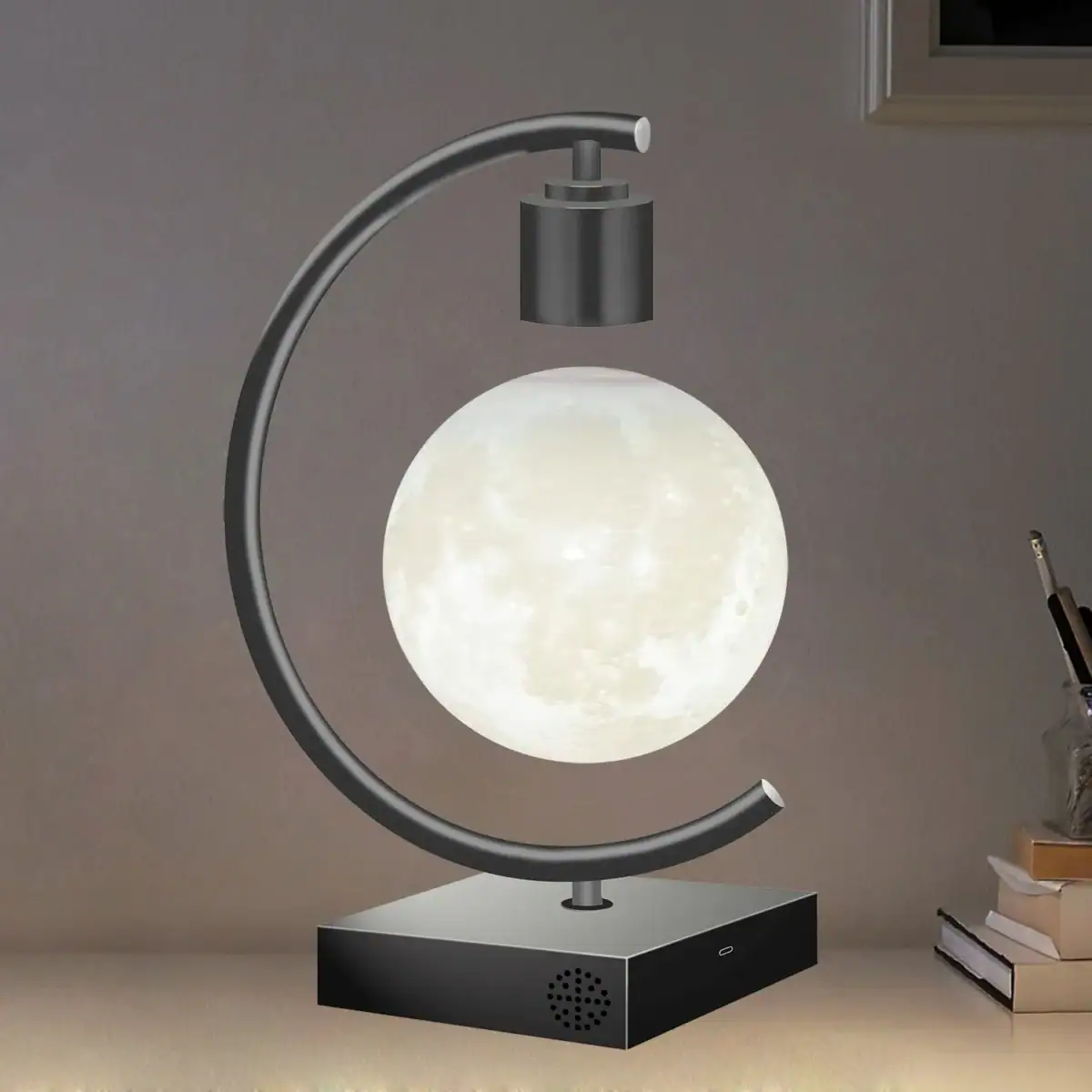 Lampe de bureau en forme de lune avec support métallique et base noire.