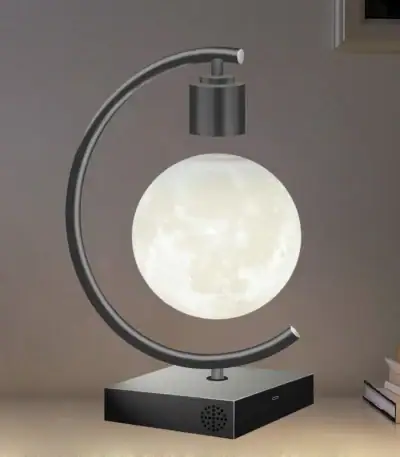 Lampe de bureau en forme de lune avec support métallique et base noire.
