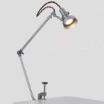 Lampe de bureau scientifique vintage avec bras articulé en métal et ampoule éclairante, idéale pour un décor de style industriel ou scientifique.