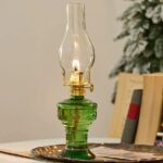 Lampe à pétrole décorative en verre vert avec flamme allumée, idéale pour une décoration scientifique ou vintage.