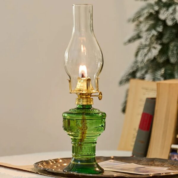 Lampe à pétrole décorative en verre vert avec flamme allumée, idéale pour une décoration scientifique ou vintage.