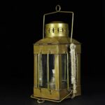 Lampe de signalisation vintage en laiton avec verre et poignée en corde, idéale pour décoration scientifique ou industrielle.