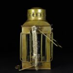 Portez une attention particulière à cette lanterne vintage en laiton, équipée d'une poignée en métal et d'une corde en fibre naturelle, idéale pour la décoration scientifique ou rétro.