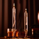Deux bougies de laboratoire en verre avec flamme vacillante, créant une ambiance chaleureuse et scientifique. Parfaites pour la décoration de science ou d'ambiance.