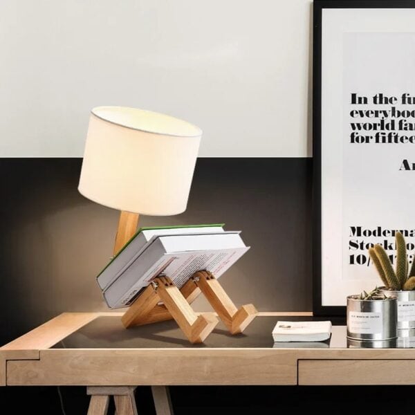 Lampe de bureau originale en forme de robot en bois avec abat-jour en tissu, idéale pour une décoration moderne et ludique dans un espace de travail ou une chambre.
