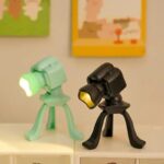 Lampe de bureau en forme de caméra, design ludique et moderne, idéale pour une décoration originale ou un espace de travail créatif.