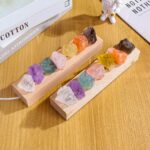 Collection de pierres précieuses colorées sur un support en bois, idéale pour la décoration scientifique ou éducative.