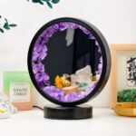 Miroir rond orné de cristaux d'améthyste violets, parfait pour une décoration intérieure élégante et apaisante.