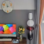 Horloge murale colorée moderne avec chiffres en relief, décoratif pour salon ou bureau.