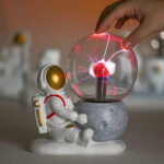 Figurine d'astronaute avec globe électrique simulant une expérience scientifique, décor de science ludique et éducative.