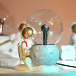 Lampe décorative en forme de planète avec un astronautes en figurine, idéale pour une décoration scientifique ou un espace enfant. Design moderne et ludique, parfait pour un univers spatial.