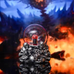 Pendentif décoratif à thème scientifique avec des petits crânes en métal et une boule de cristal rouge, idéal pour les amateurs de science et de décoration originale.