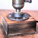 Pupitre d'expérimentation scientifique en bois et métal, utilisé pour des expériences éducatives ou de décoration scientifique, avec une base en bois massif et un support métallique.