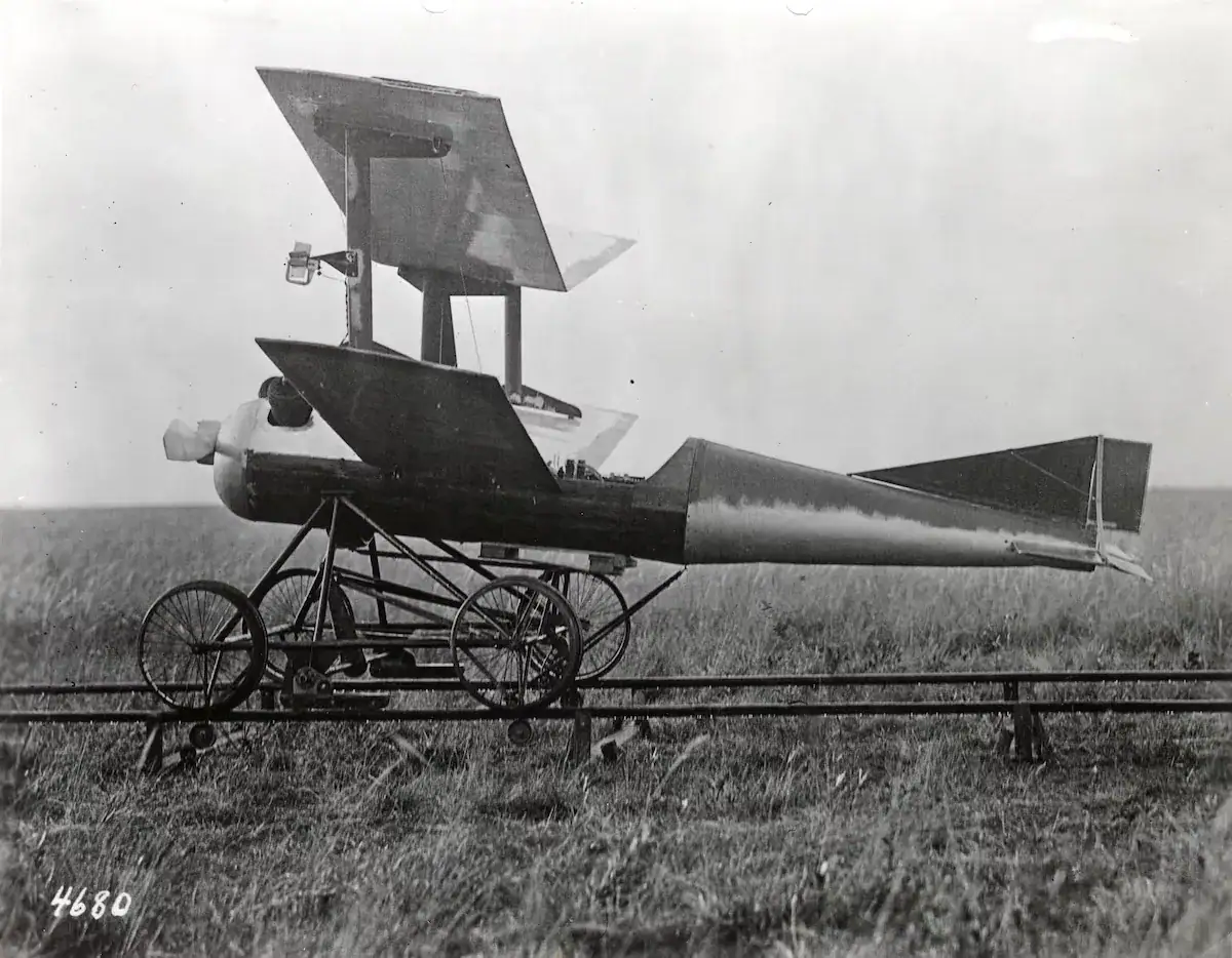 Véhicule expérimental historique avec ailes et fuselage en forme de fusée, posé sur un terrain herbeux, illustrant une innovation en aéronautique ancienne.