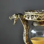Porte-encens serpent en métal doré avec tête de serpent détaillée, parfait pour la décoration de style scientifique ou mystique.